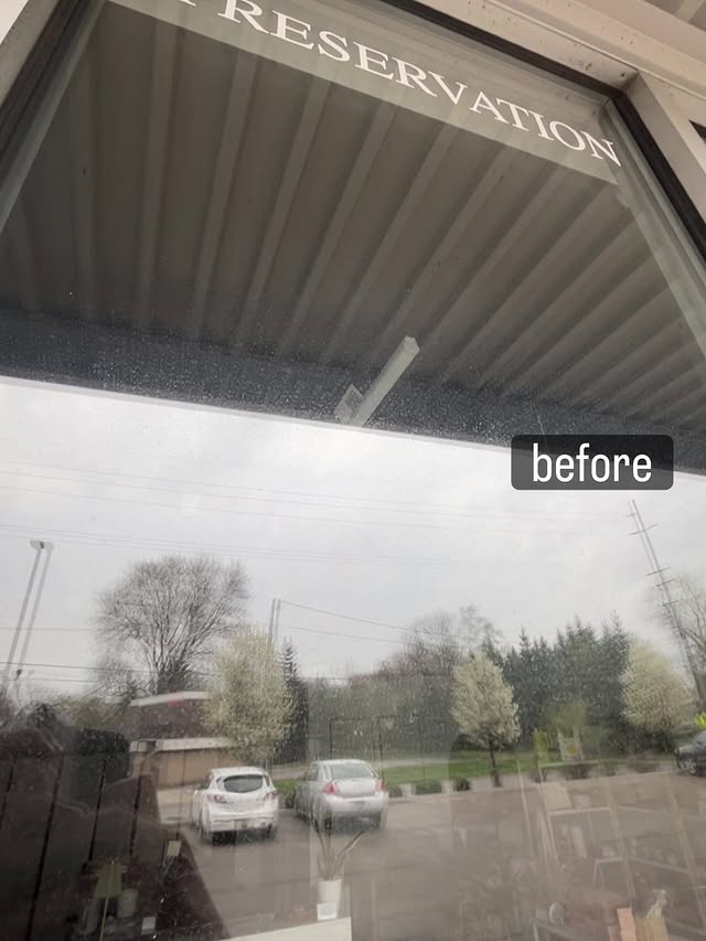 Storefront window before cleaning — visible rain spots and grime